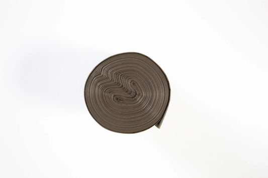 Rolka czarnych worków na śmieci na białym tle, plastikowe worki zwinięte w spiralę