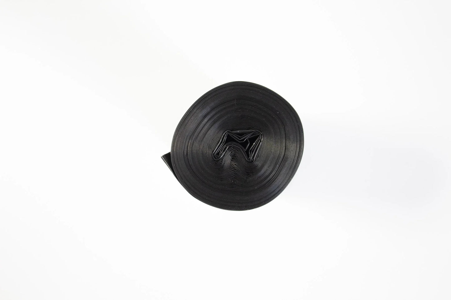 Rolka czarnych worków na śmieci na białym tle, pakowanie i sprzątanie