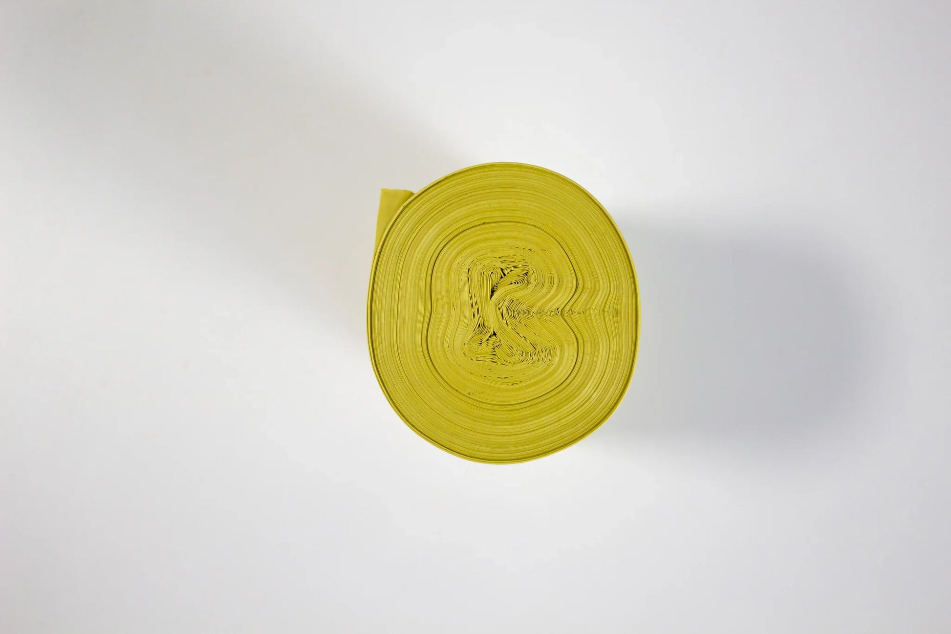 Zwój żółtych worków na śmieci czarnych na białym tle, widok z góry